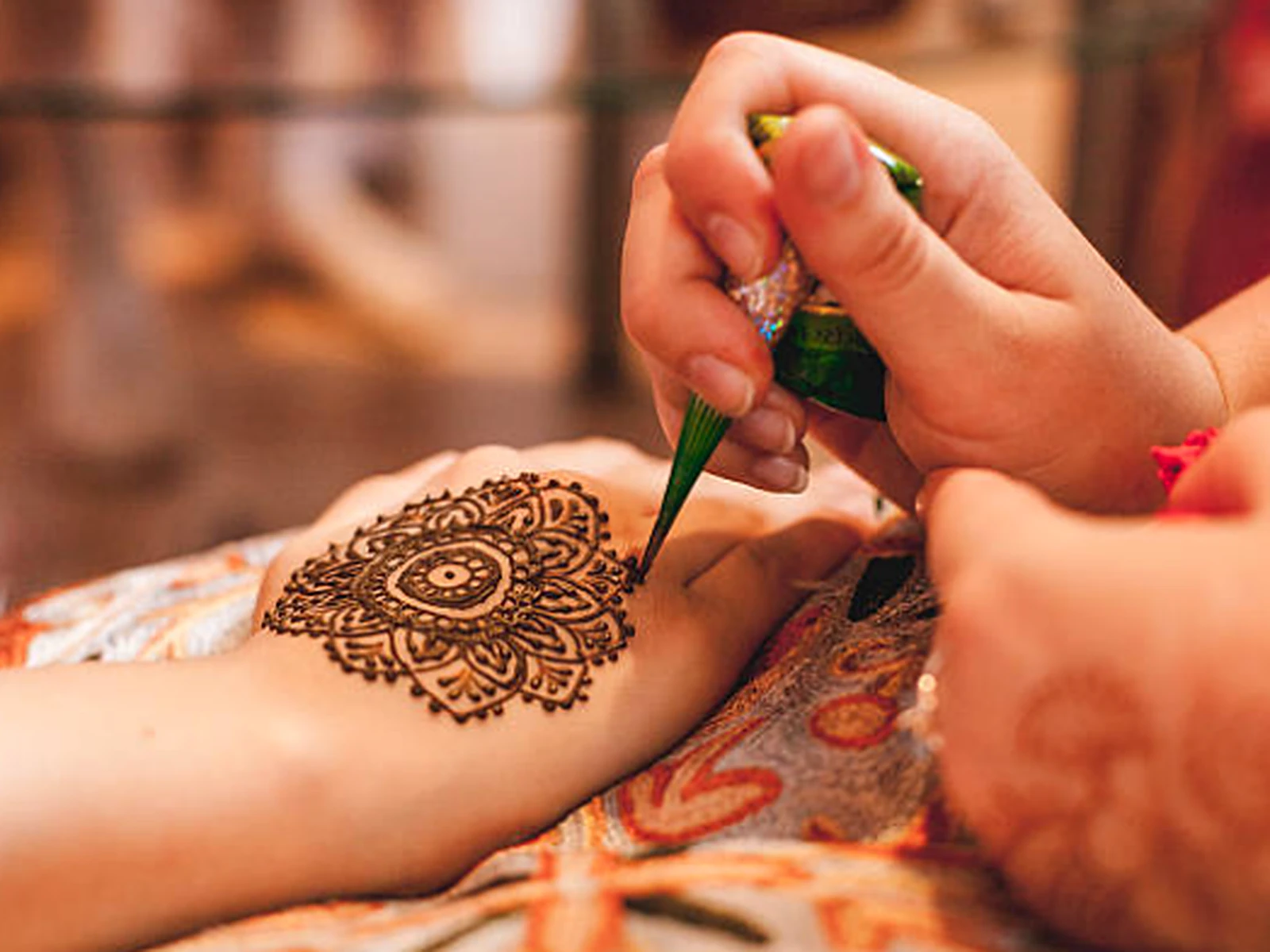 Henna being painted on a guest's hand