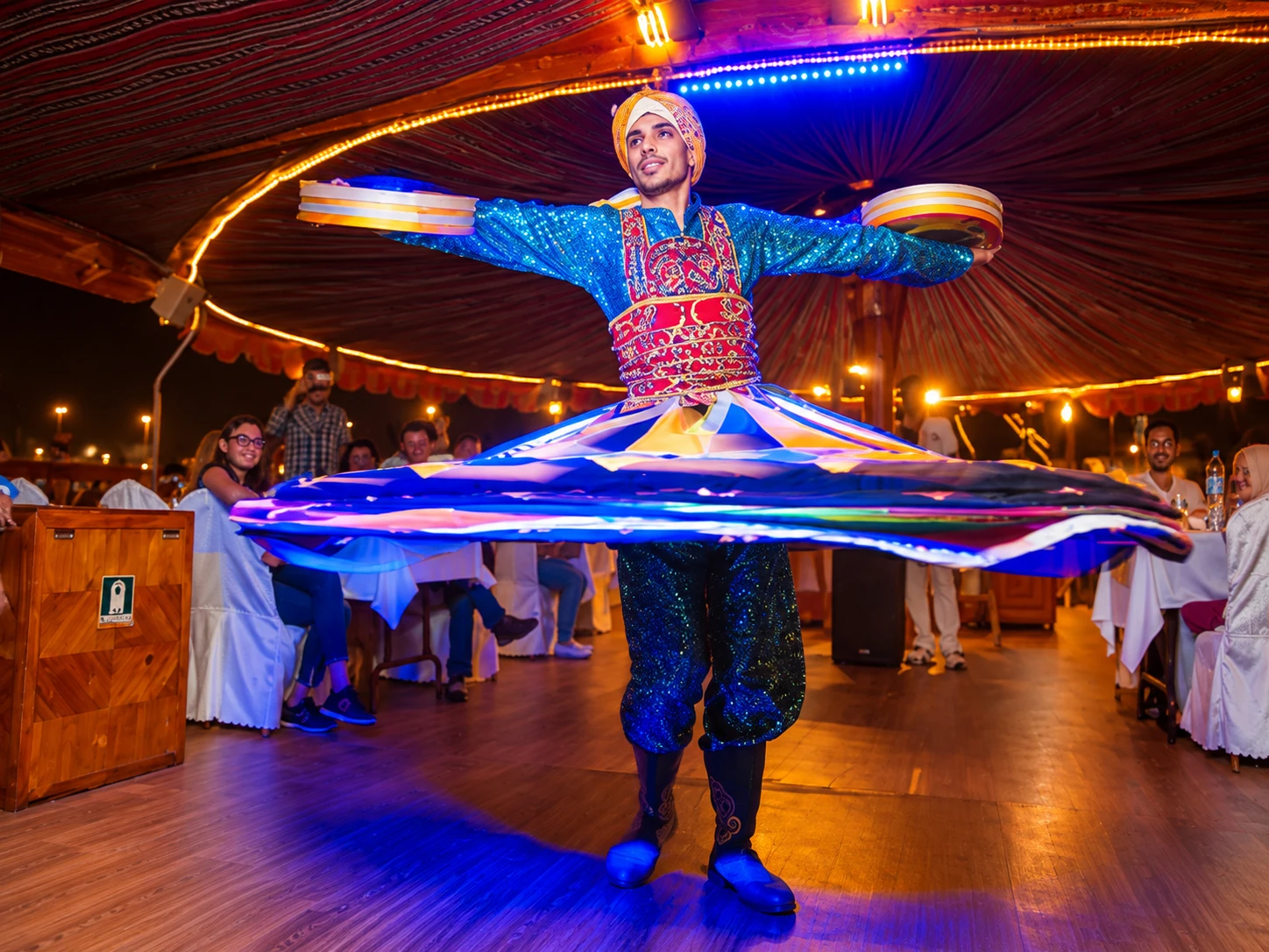 A tanoura dance performer spinning in a colourful skirt
