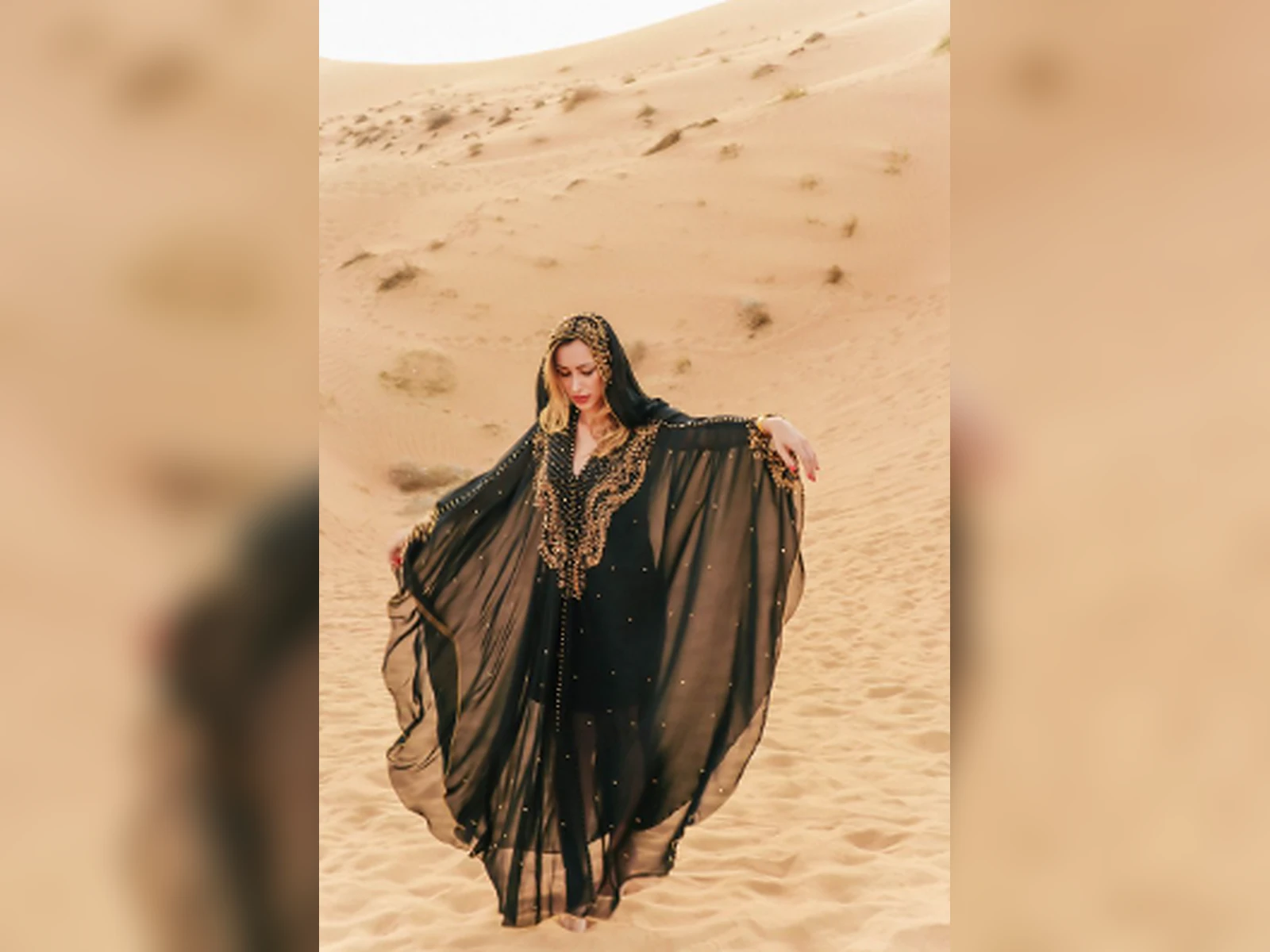 A guest in traditional dress on the desert dunes
