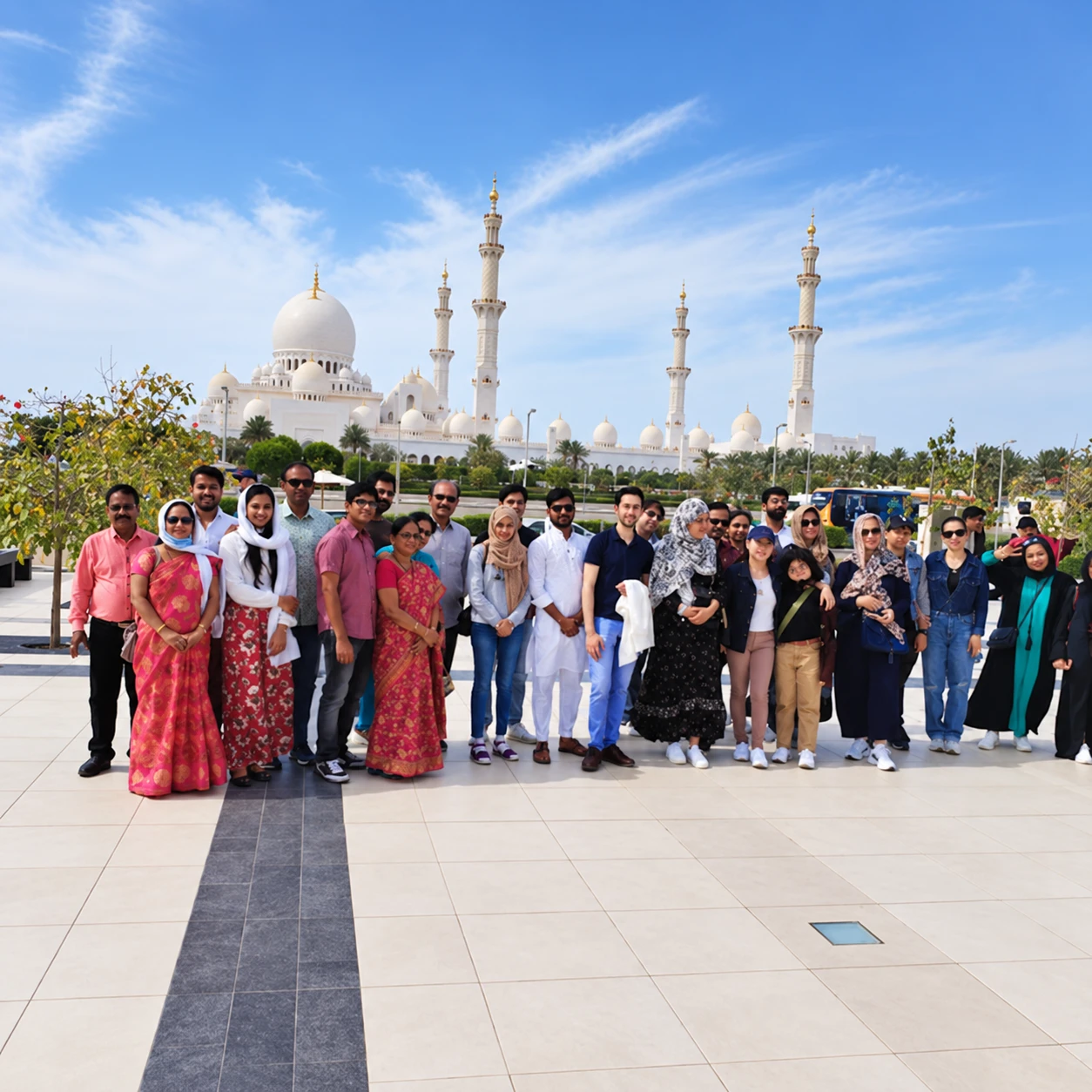 Group of guests with the Sheikh Zayed Grand Mosque and its minarets behind them