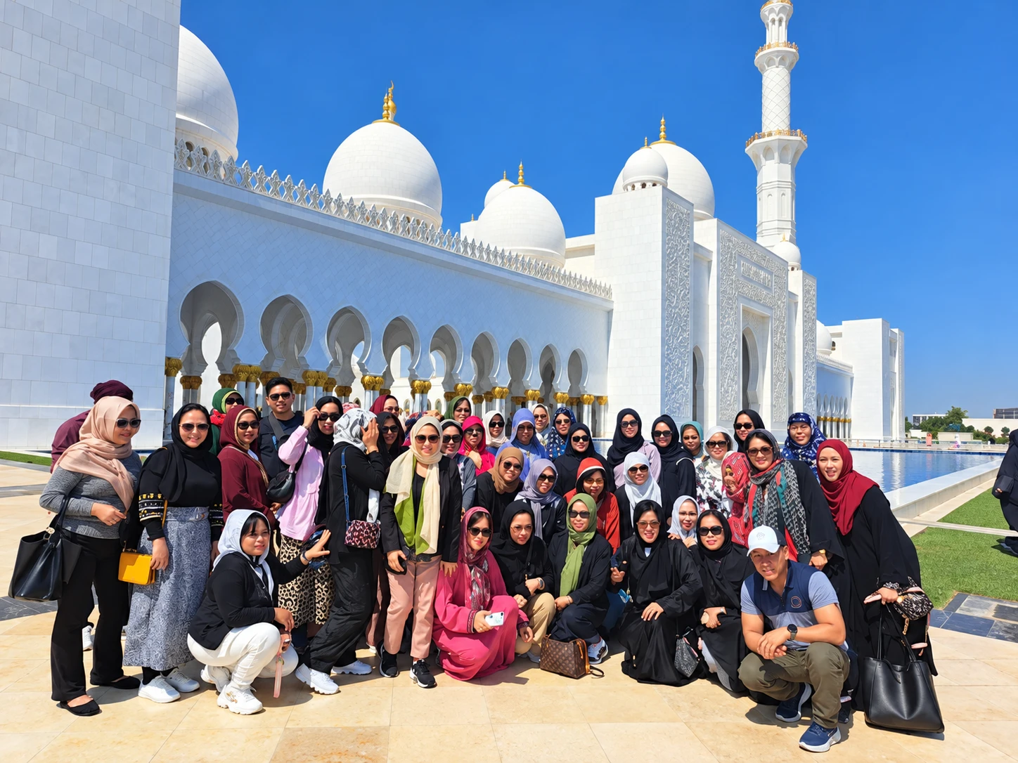 Group of guests in front of the white domes of the Sheikh Zayed Grand Mosque